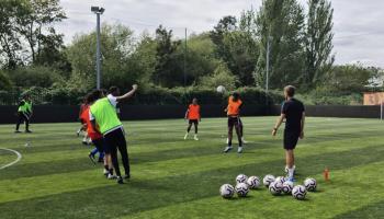 Boys at football practice on grass pitch