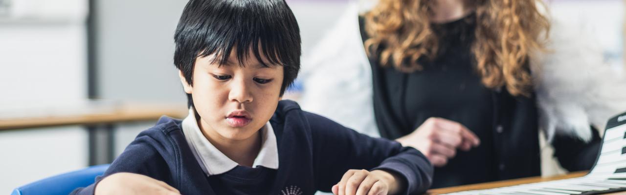 A young boy developing his reading skills with his tutor